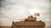 FILE - American soldiers drive a Bradley Fighting Vehicle during a joint exercise with Syrian Democratic Forces at the countryside of Deir Ezzor in northeastern Syria, Dec. 8, 2021.