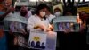 Indians hold placards and candles during a protest against banning Muslim girls wearing hijab from attending classes at some schools in the southern Indian state of Karnataka, in Bengaluru, Karnataka state, India, Feb. 19, 2022.