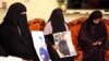 FILE - Family members hold pictures of a 20-year-old Libyan suspected to have been disappeared, at his home in the Sidi Essid district of the city of Tarhuna, southeast of the Libyan capital Tripoli, Nov. 10, 2020. 