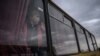 FILE - A girl looks out from a bus as families from Russian occupied territories in Ukraine's Zaporizhzhia region arrive in a humanitarian convoy at a registration and processing center for internally displaced people.