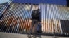 FILE - A migrant waits on the Mexican side of the border after U.S. Customs and Border Protection officers detained a couple of migrants crossing the U.S.-Mexico border on the beach, in Tijuana, Mexico, Jan. 26, 2022.