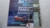 FILE - Workers put on a giant poster for government subsidies for Dongfeng Peugeot cars at a dealership in Wuhan, Hubei province, China, Aug. 9, 2020. 