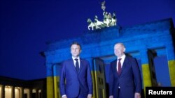 Архівне фото: Канцлер Німеччини Олаф Шольц та президент Франції Еммануель Макрон біля Брандербурзьких воріт, освітлених в кольори українського прапору. 9 травня 2022 року. REUTERS/Мішель Тантуссік