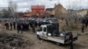 FILE - French forensics investigators, who arrived in Ukraine for the investigation of war crimes amid Russia's invasion, stand next to a mass grave in the town of Bucha, in Kyiv region, Ukraine, Apr. 12, 2022. 