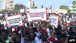 FILE - Senegalese journalists hold banners and shout slogans during the march for the release of their colleague Pape Ale Niang in Dakar, Nov. 18, 2022.