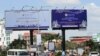 ប្រជាពលរដ្ឋធ្វើដំណើរឆ្លងកាត់ផ្ទាំងបដានៃកិច្ចប្រជុំកំពូលអាស៊ាន នៅត្រង់រង្វង់មូលគល់ស្ពានជ្រោយចង្វា ក្នុងរាជធានីភ្នំពេញ នៅថ្ងៃទី០៧ ខែវិច្ឆិកា ឆ្នាំ២០២២។ (លាស់ លីបលីប/វីអូអេ)