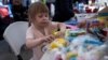 На фото: Українська дитина, яка шукає притулку в Сполучених Штатах, робить колаж на пасхальну тематику в спортивному комплексі Беніто Хуарес, створеному місцевою владою в Тіхуані, Мексика, 13 квітня 2022 року. REUTERS/Toya Sarno Jordan