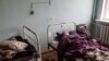 A woman lies in a bed at a delapidated hospital in the town of Severodonetsk, in Ukraine's war-ravaged Luhansk region, April 14, 2022.