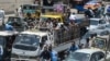 People ride on the back of a mini truck after the government resumed public transport services easing the lockdown imposed against the COVID-19 coronavirus, in Pakistan's port city of Karachi, June 3, 2020. 