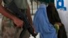 Women fleeing a military offensive in South Waziristan are guarded by a soldier as they await their turn at a registration point for internally displaced persons (IDPs) in Dera Ismail Khan, located in Pakistan's restive North West Frontier Province Octobe