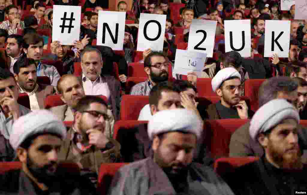 Participants hold signs during a campaign gathering for conservatives before the upcoming parliamentary elections and the upcoming vote on the Assembly of Experts, in Tehran, Iran.