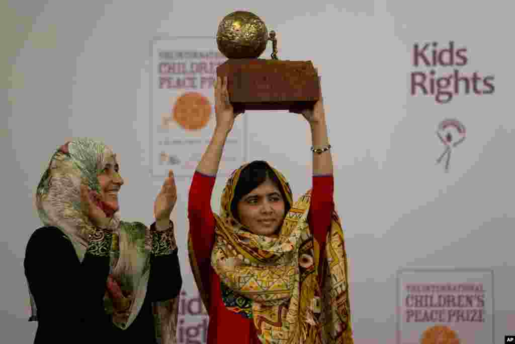 Remaja putri Pakistan, Malala Yousafzai, kanan, yang luka ditembak oleh Taliban karena mendukung pendidikan untuk anak perempuan, mendapatkan Penghargaan Perdamaian Anak-anak Internasional 2013 yang diserahkan oleh pemenang Hadiah Nobel Perdamaian 2011 Tawakkol Karman dari Yaman, dalam sebuah acara di Hall of Knights di Den Haag, Belanda.