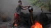 FILE - A man working at an illegal oil refinery site pours oil under a locally made burner to keep the fire going, near river Nun in Nigeria&#39;s oil state of Bayelsa.