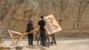 Production crews remove a sign after dangerously high winds forced President Joe Biden to cancel a trip Jan. 7, 2025, to the Eastern Coachella Valley, California, where he was to announce the creation of two new national monuments in California.