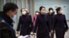 Flight crew members wearing face masks walk through the international arrivals area at Beijing Capital International Airport in Beijing, Thursday, Jan. 30, 2020. China counted 170 deaths from a new virus Thursday and more countries reported…