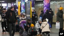 Watu wamekusanyika katika kituo cha treni ya ardhini kinachotumika kujihifadhi na mashambulizi ya mabomu na roketi yanayofanywa na Russia dhidi ya mji wa Kyiv, Ukraine, Jan 26, 2023.