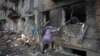 FILE - People gather their belongings from a damaged building after Russian shelling in the town of Vyshhorod, Ukraine, Nov. 24, 2022. The U.N. reports that more than 10 million Ukrainians are facing winter without water, heat or electricity.