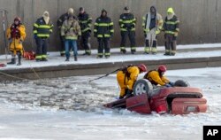 Regu penyelamat dari satuan pemadam kebakaran kota Kansas berupaya mengangkat mobil minivan yang terpelosok ke Sungai Brush di Kansas City, Missouri, 22 Desember 2022. (Nick Wagner/The Kansas City Star via AP)