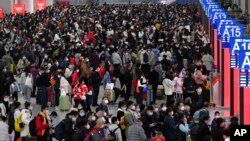 广东深圳南站大厅内，旅客们人们带着口罩和行李，熙熙攘攘挤满大厅，等待买票和登车。（2023年1月7日）