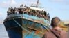 FILE - Migrants stand onboard a fishing boat at the port of Paleochora, following a rescue operation off the island of Crete, Greece, Nov. 22, 2022.