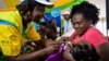 FILE - A health worker vaccinates a child against malaria in Homabay County, western Kenya, Sept.13, 2019. Malaria hospitalizations and deaths fell the vaccine's pilot program countries of Kenya, Ghana and Malawi and a mass rollout of the vaccine is underway.