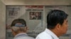Men are seen at a newspaper display reporting on U.S. House Speaker Nancy Pelosi's Asia visit, at a stand in Beijing, China, July 31, 2022. 