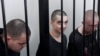 Двоє громадян Великої Британії Ейден Аслін і Шон Піннер і марокканець Саудун Брагім за ґратами в залі суду в Донецьку, на території, що підконтрольна уряду Донецької Народної Республіки, на сході України, четвер, 9 червня 2022 р. (AP Photo)