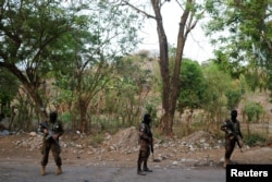Soldiers stand at a checkpoint in the Distrito Italia neighborhood after El Salvador's Congress approved emergency powers that temporarily suspended some constitutional protections after the Central American country recorded a sharp rise in killings attributed to criminal gangs, in Tonacatepeque, El Salvador, April 4, 2022.