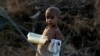 A child displaced by flooding from monsoon rains eats food at a make-shift tent camp for flood victims, in Sukkur, Pakistan, Sept. 7, 2022.