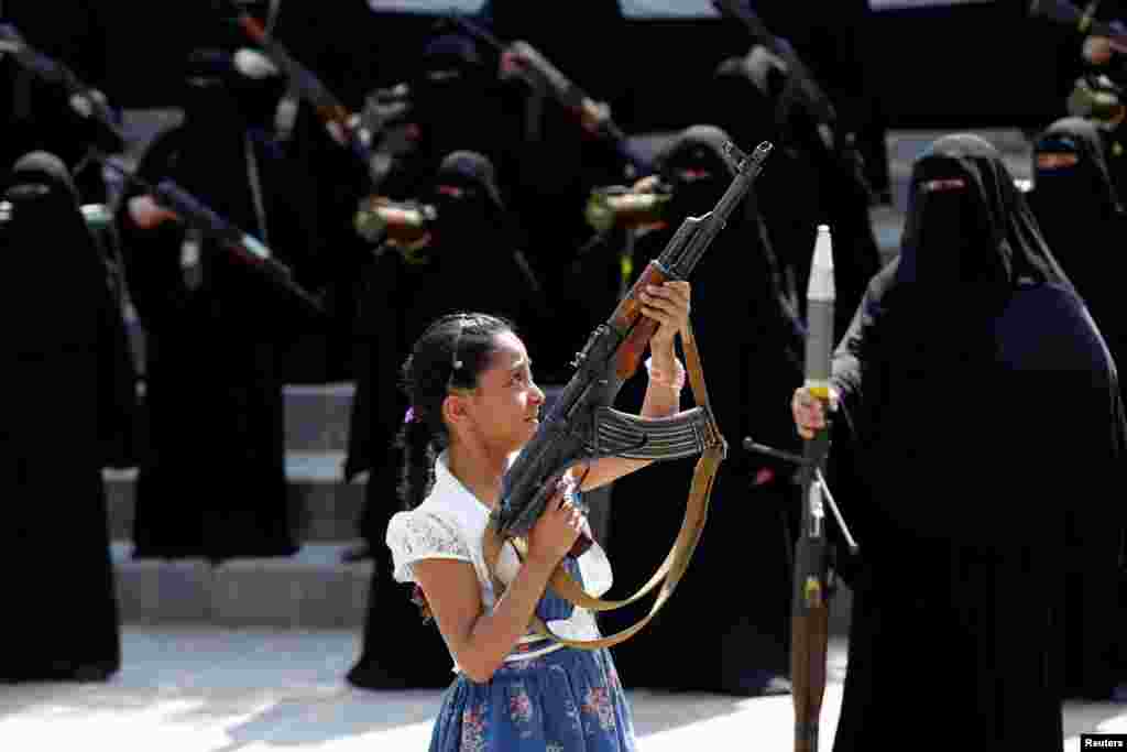 Seorang anak perempuan memegang senjata dalam sebuah aksi unjuk rasa para perempuan Yaman pendukung pemberontak Houthi di ibukota Sana&#39;a.