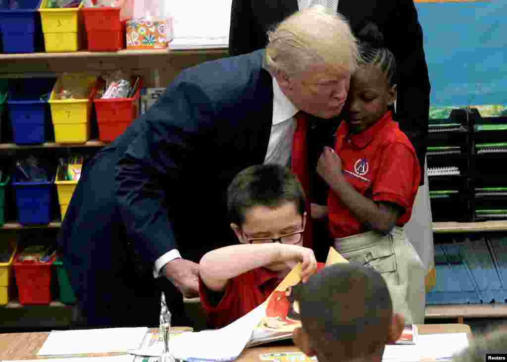 Capres partai Republik Donald Trump memeluk seorang pelajar setelah menerima hadiah kitab Injil pada kampanye di sebuah gereja di Las Vegas, Nevada.