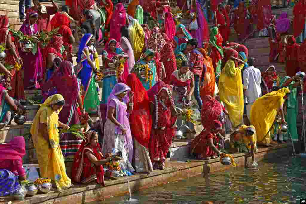 Hindu women collect water from the Pushkar lake to pour on idols of Lord Shiva, on occasion of Mahashivratri festival in Pushkar.