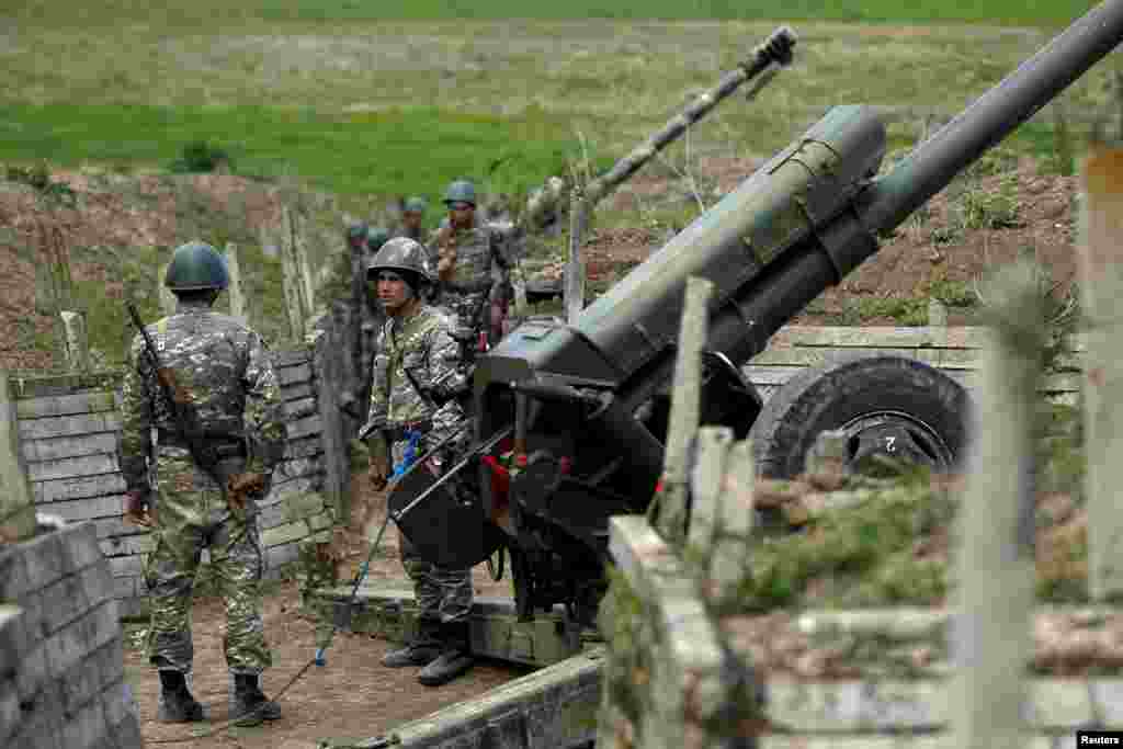 Ethnic Armenian soldiers stand next to a cannon at artillery positions near the Nagorno-Karabakh's town of Martuni.