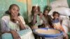 FILE - Tesfay sits with his wife and grandchildren, who have been displaced, as they receive food assistance for the first time in eight months from the World Food Program (WFP), in Mehameday, in Ethiopia's Tigray region, May 28, 2022. 