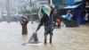 People wade through the water as they look for shelter during a flood, amidst heavy rains that caused widespread flooding in the northeastern part of the country, in Sylhet, Bangladesh, June 18, 2022.