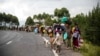 FILE - People walk on the road near Kibumba, north of Goma, Democratic Republic of the Congo, as they flee fighting between Congolese forces and M23 rebels in North Kivu, May 24, 2022.