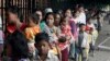 FILE - Cambodian villagers for countryside line up as wait for a medical check-up outside the children hospital of Kuntha Bopha, in Phnom Penh, Cambodia, Wednesday, July 11, 2012. 