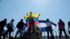 FILE - Anti-government protesters hold flags and shout slogans to riot police during a demonstration against Nicaraguan President Daniel Ortega's government in Managua, Nicaragua, March 30, 2019. 