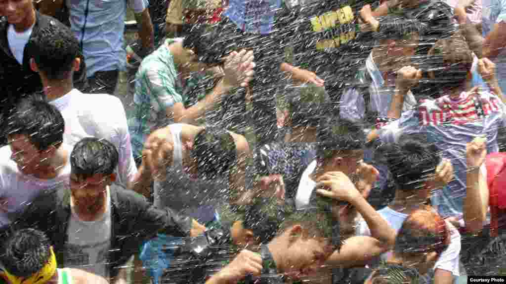 Festival air hari keempat dimulai dengan percikan air untuk menenangkan diri tapi lambat laun berevolusi menjadi perang air menggunakan selang dan pistol air dan menari di jalanan. (MoeMoe Htun/VOA).