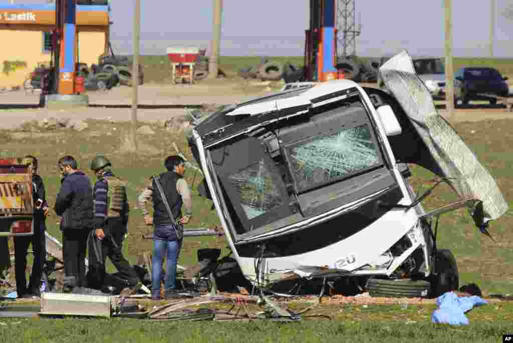 Members of Turkish forces gather around a bus that was destroyed in an explosion on the road linking the cities of Diyarbakir and Bingol, in southeastern Turkey. Six soldiers were killed after PKK rebels detonated a bomb on the road as their vehicle was passing by, according to Turkey&rsquo;s state-run Anadolu Agency. The deaths come a day after a suicide bombing claimed the lives of at least 28 people and wounded dozens of others.