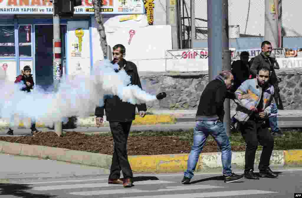 People react as a tear gas canister is thrown by Turkish police during clashes in central Diyarbakir. Turkish security forces clashed with rebels in the main city of the Kurdish-dominated southeast, days after a deadly bombing in Ankara claimed by the Kurdistan Freedom Falcons (TAK), a radical Kurdish group with ties to the outlawed Kurdistan Workers&#39; Party.