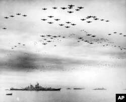 FILE - In this Sept. 2, 1945, file image provided by the U.S. Navy, F4U and F6F fighter planes fly in formation over the USS Missouri while the surrender ceremonies to end World War II take place aboard the U.S. Navy battleship in Tokyo Bay.