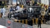 Pakistani security personnel surround a damaged police van in Lahore, Pakistan, Wednesday, May 8, 2019.