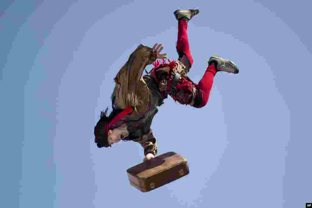  An acrobat jumps from the top of a school building during a performance for children of foreign migrant workers to celebrate the Purim festival in Tel Aviv, Israel.