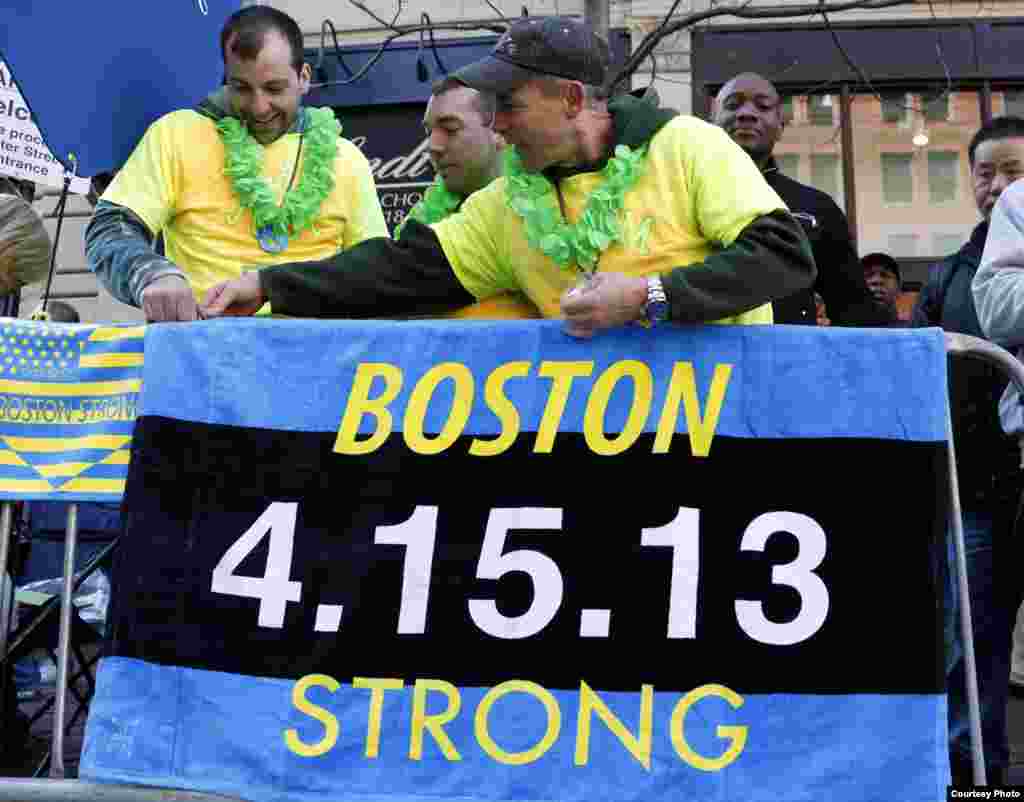 Andrew Lembcke (kiri), Brandon Petrich (tengah) dan Bill Januszewski memasang baner Boston Strong sebelum Boston Marathon 2014 dimulai, Boston, 21 April 2014. (Greg M. Cooper-USA TODAY)