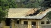 FILE - A woman stands outside a damaged school dormitory after it was set on fire in Bafut, in the Northwest English-speaking region of Cameroon, Nov. 15, 2017. 