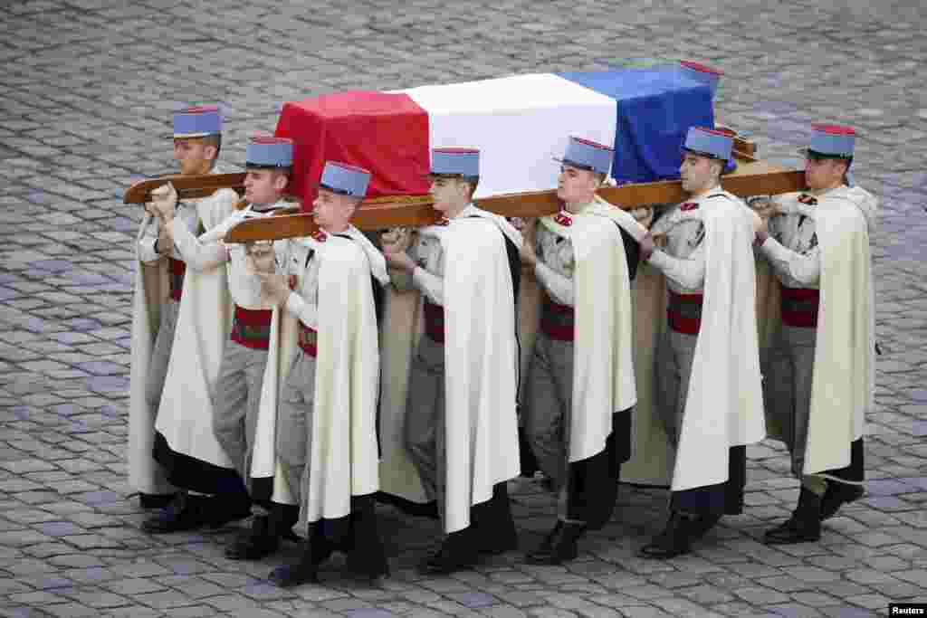 French Foreign Legionnaires carry the coffin of politician Yves Guena during an official funeral ceremony at the Hotel des Invalides in Paris.