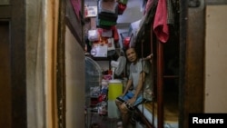 FILE - Kwok Kwai, 65, poses for a photo inside his subdivided flat in Hong Kong, Aug. 8, 2024. 