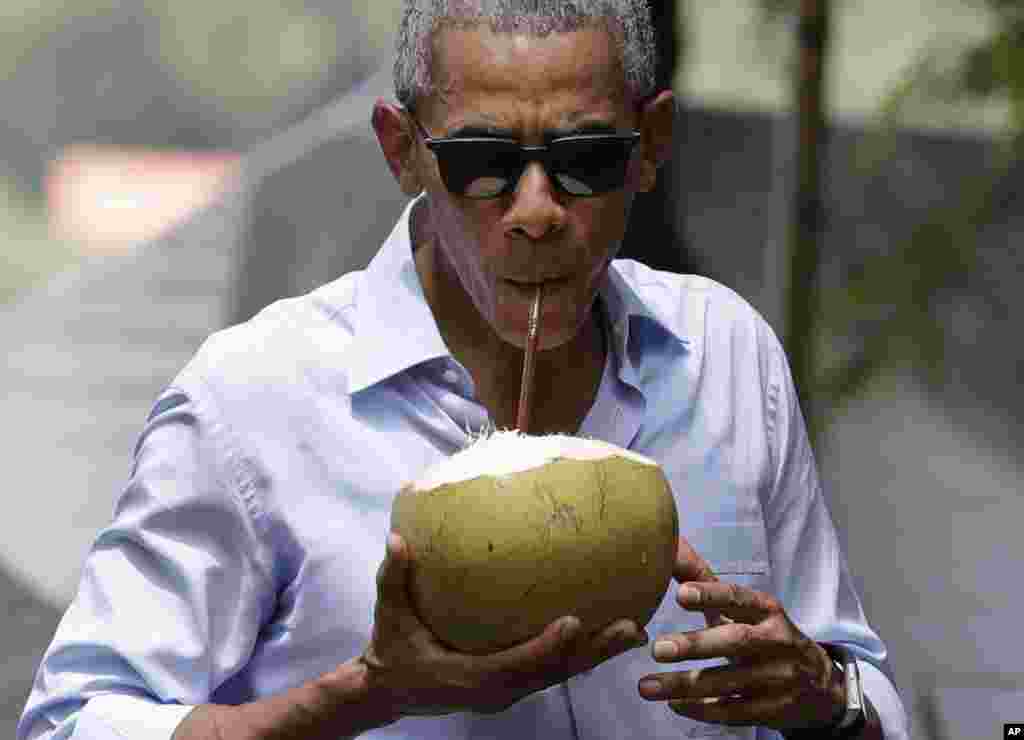 Presiden AS Barack Obama minum kelapa muda segar di dekat Sungai Mekong di Luang Prabang, Laos (7/9).&nbsp;(AP/Carolyn Kaster)