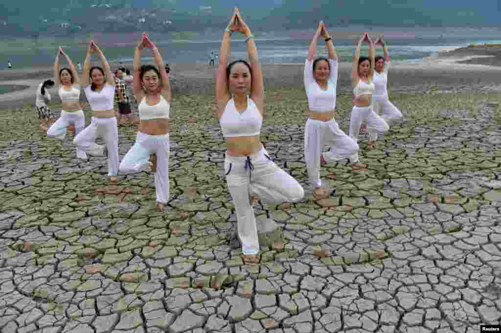 Para perempuan melakukan yoga di sungai Yunyang yang kering, Chongqing, China.